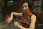 Молодая китаянка осваивает искусство танца у мастера в старом дворике Пекина.